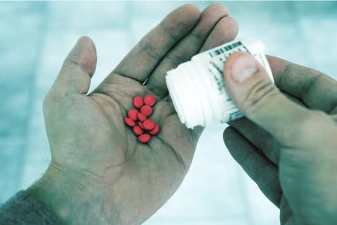 Hand mit Tabletten zur Einnahme für verbesserte Leistungsfähigkeit